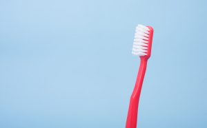 Image of a red toothbrush on a blue background